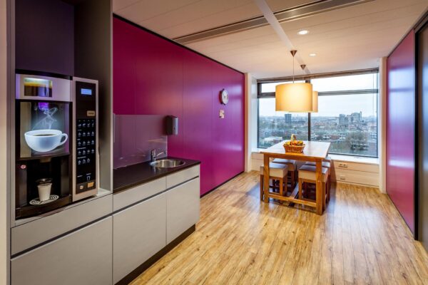 Moderne kantoorkeuken aan de Prinses Beatrixlaan met een koffieautomaat, eettafel en uitzicht over de stad.